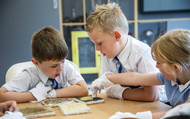 Skipton Town Hall_17 Three children handling museum objects whilst wearing white gloves