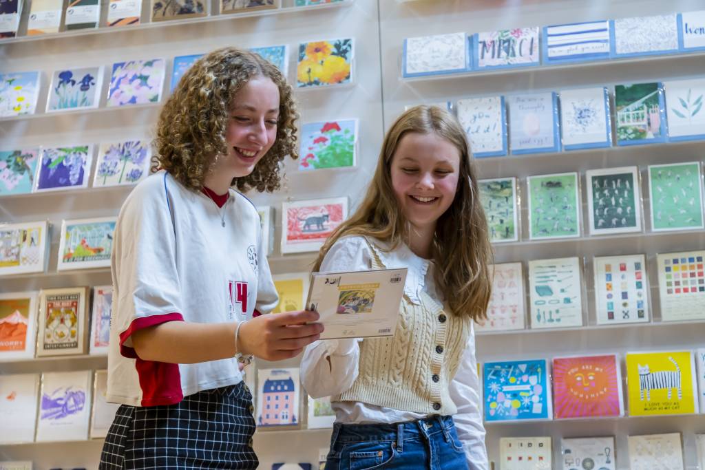 Skipton Town Hall_77 Two teenage girls looking at a greetings card and smiling.
