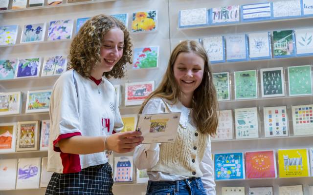 Skipton Town Hall_77 Two teenage girls looking at a greetings card and smiling.