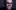Colin Manford A man with dark hair and glasses with his hand over his mouth